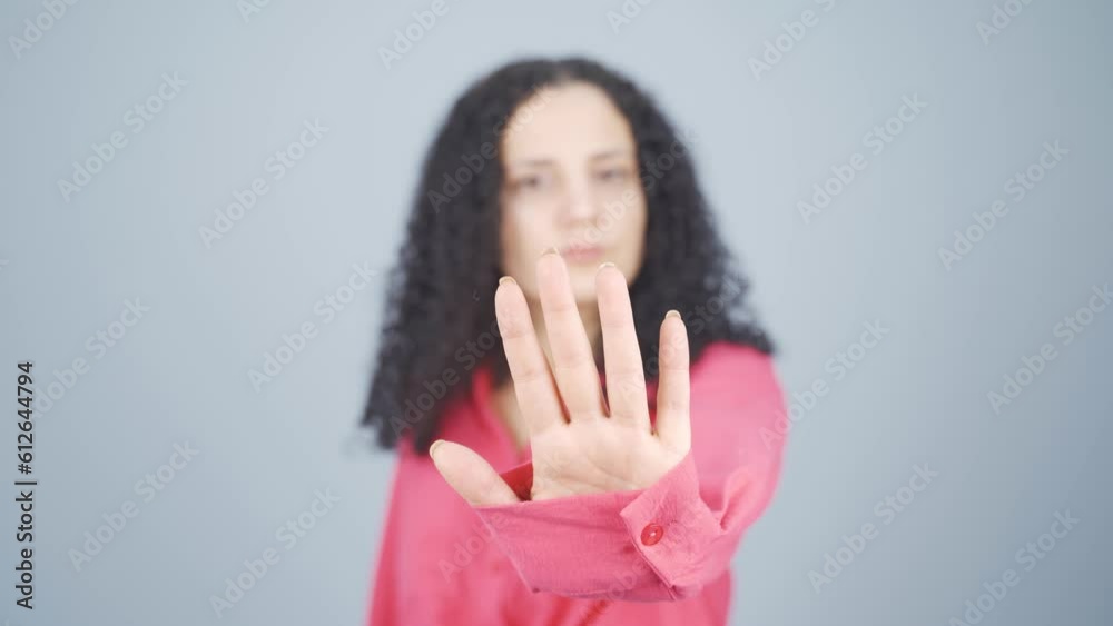 Young woman making stop sign for camera. Young woman making stop sign for camera.