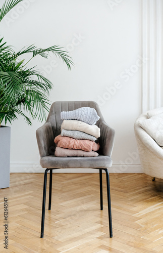 Stack of sweaters on chair  photo