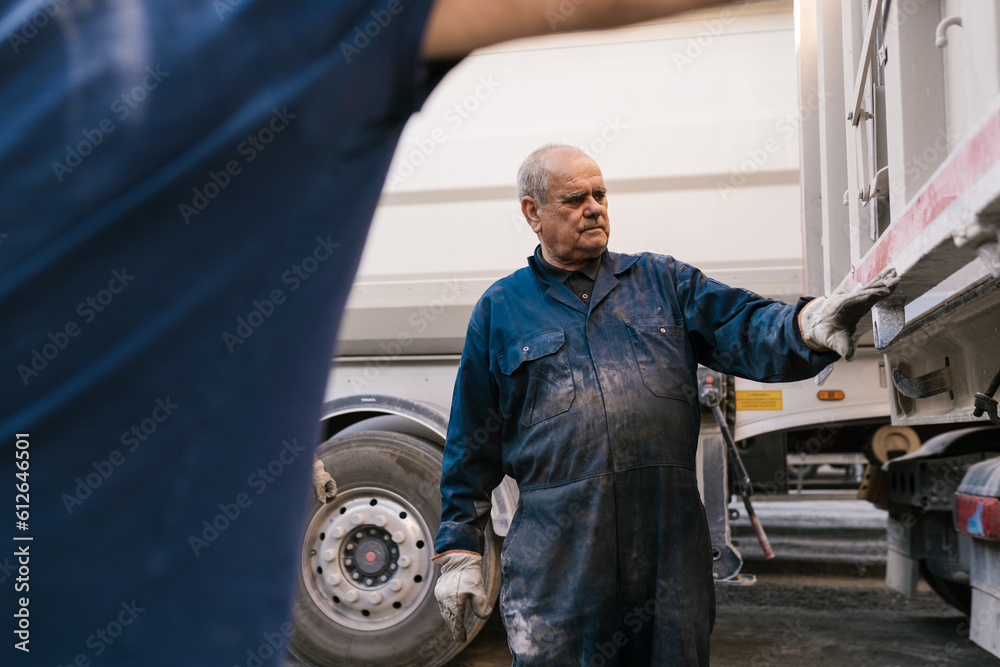 Senior mechanic checking truck before repair Senior mechanic checking truck before repair