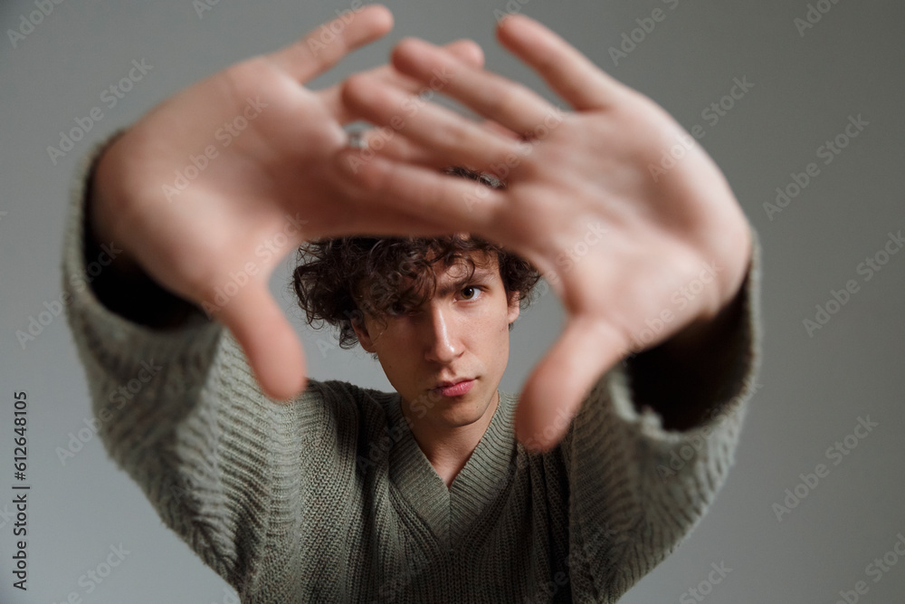 Man showing stop gesture in gray studio Man showing stop gesture in gray studio