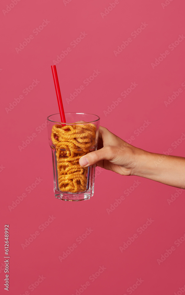 © Javier Díez/Stocksy - Crop female showing glass with wool yarn and straw