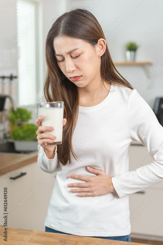 Pain, suffering asian young woman having a stomachache, abdominal pain or digestive, hand in