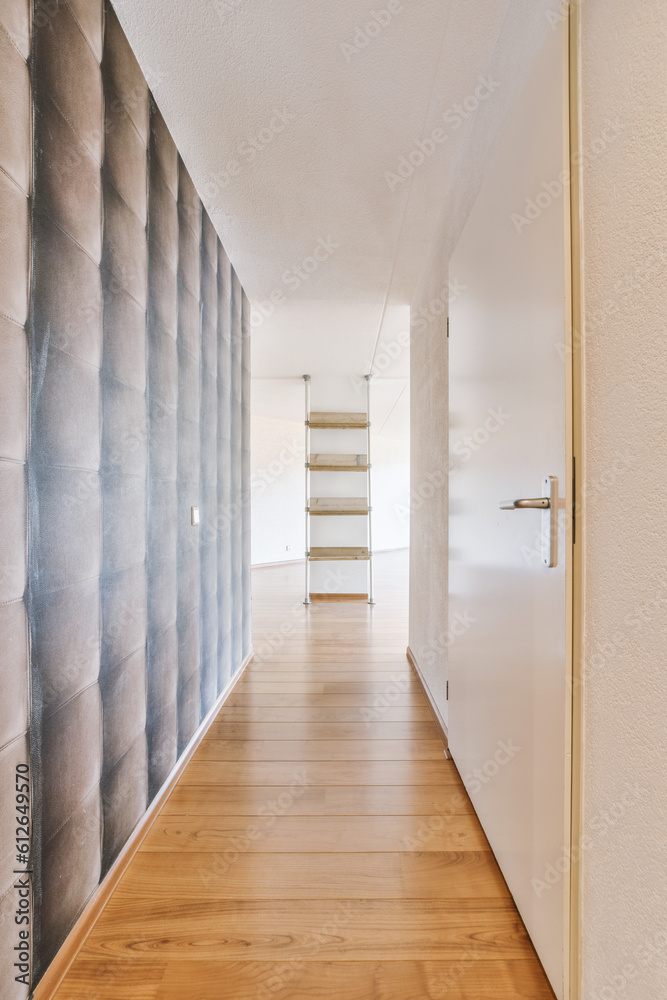 a long hallway with wood flooring and wallpapers on the walls in an empty room that has been painted white