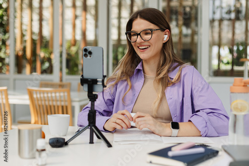 Happy woman recording video in coworking photo