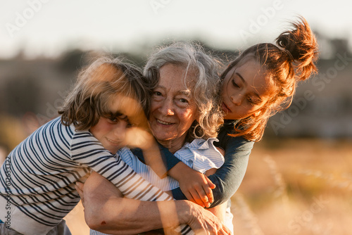 Loving kids with grandmother outdoors