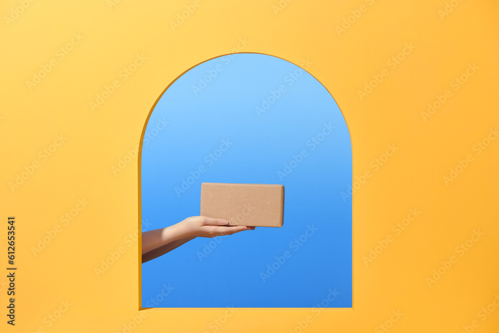 © Marc Tran/Stocksy - Delivery man hand holding parcel cardboard box © Marc Tran/Stocksy - Delivery man hand holding parcel cardboard box