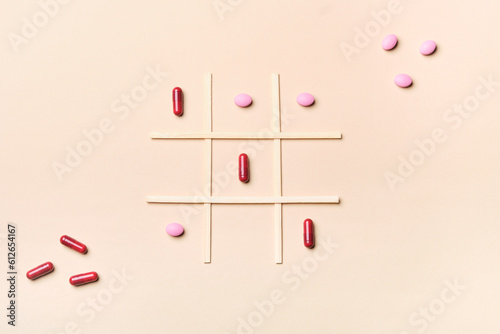 pills and capsules on a tic tac toe