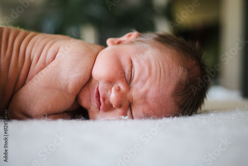 Wrinkly squinting newborn on blanket. photo