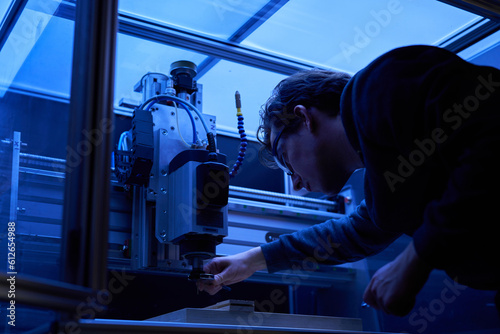 A man operating a computer numerical control machine