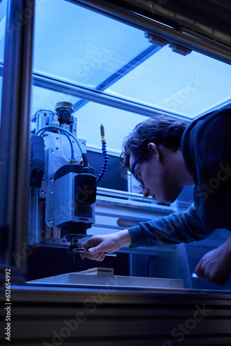 A man operating a computer numerical control machine