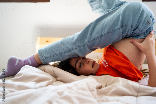  girl doing a somersault on the bed looking at camera photo