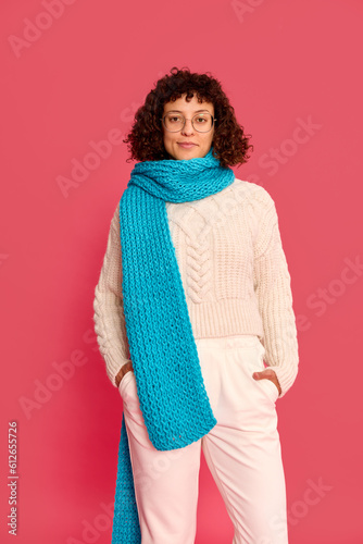 Joyful woman standing with blue scarf and looking at camera in s photo