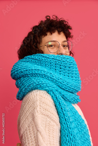 Joyful woman standing with blue scarf and looking at camera in s photo