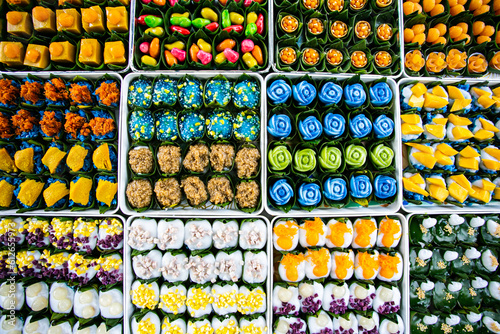 A background image of a variety of Thai desserts placed in trays and arranged beautifully.