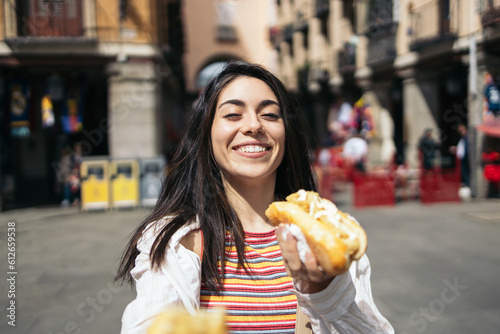 Young woman visiting Madrid eating a typical calamari sandwich. photo