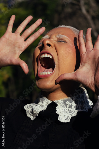 A Gothic Woman with Shaved White Hair and a Black Dress and screaming