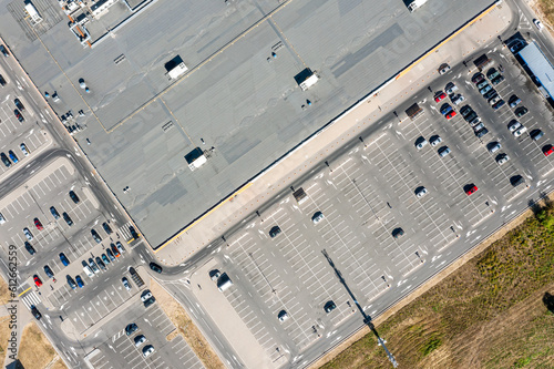 supermarket roof and many cars in parking. aerial drone photo looking down.