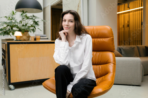 Portrait of a young attractive woman in a designer chair photo
