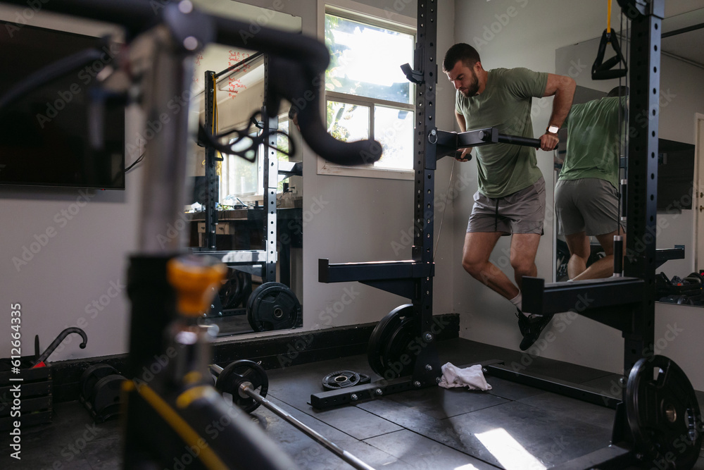 Athlete doing tricep dips in garage gym. Athlete doing tricep dips in garage gym.