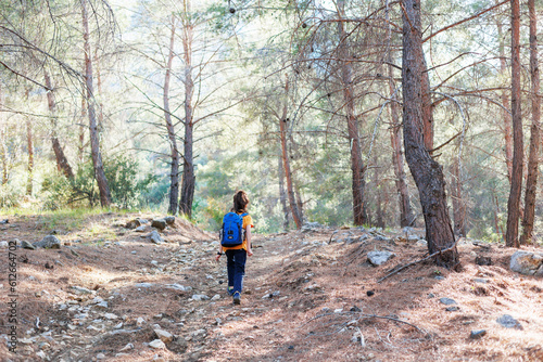 Traveling child. a tourist with a backpack goes along a mountain road. adventure holidays with children.