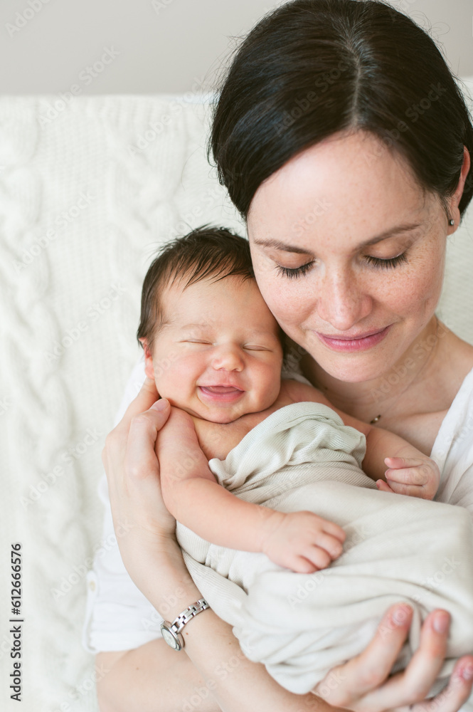 Portrait of a mother embracing her smiling newborn baby. Portrait of a mother embracing her smiling newborn baby.