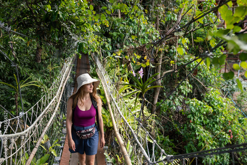 Tourist Walking At Suspension Bridge In The Jungle photo