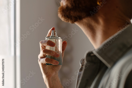 Man applying perfume to his neck photo
