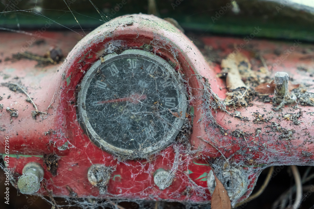 Speedometer on the red dashboard of an abandoned old sports car
