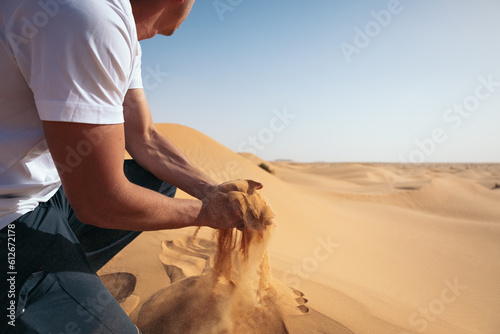 Man picking up desert sand between his hands