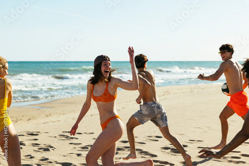Happy diverse friends walking on beach