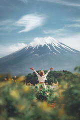 Happy tourist traveler woman enjoying with open arms on lake kawaguchiko with mount fuji in japan, spring and summer, Japan travel vacation