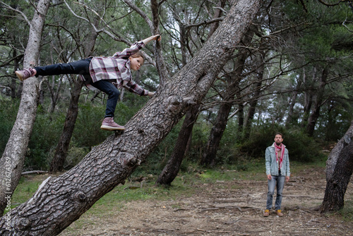 Little girl on the pine tree photo