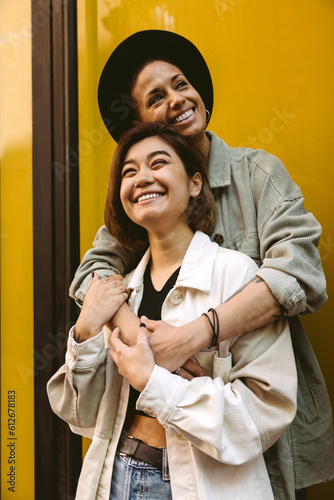 Cheerful girlfriends embracing on street photo