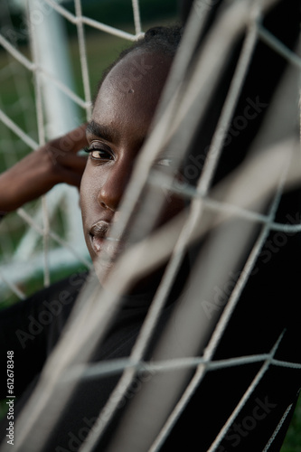 African American woman lies in a football goal net on the field  photo