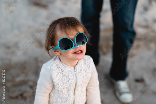 Little girl wears sunglasses upside down photo