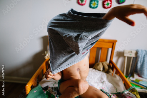 Little boy tries to get dressed photo