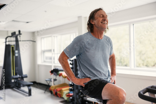 Sweaty, tired, happy older man recovering after spin workout. photo