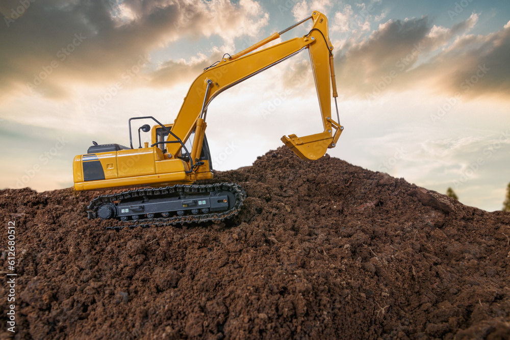 Crawler excavator is digging soil in the construction site with sunset backgrounds. Crawler excavator is digging soil in the construction site with sunset backgrounds.
