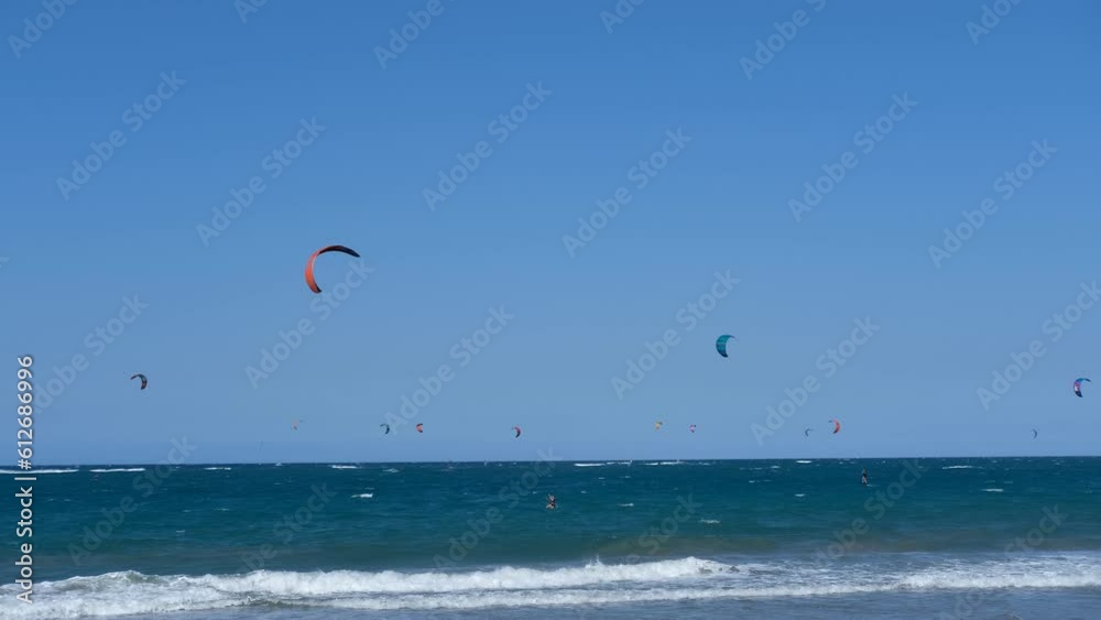 Panoramic sea view with kitesurfing sails. people enjoy riding a kitesurfing board on a bright sunny day, by the sea or ocean. Water sports, adrenaline, fun, adventure Panoramic sea view with kitesurfing sails. people enjoy riding a kitesurfing board on a bright sunny day, by the sea or ocean. Water sports, adrenaline, fun, adventure
