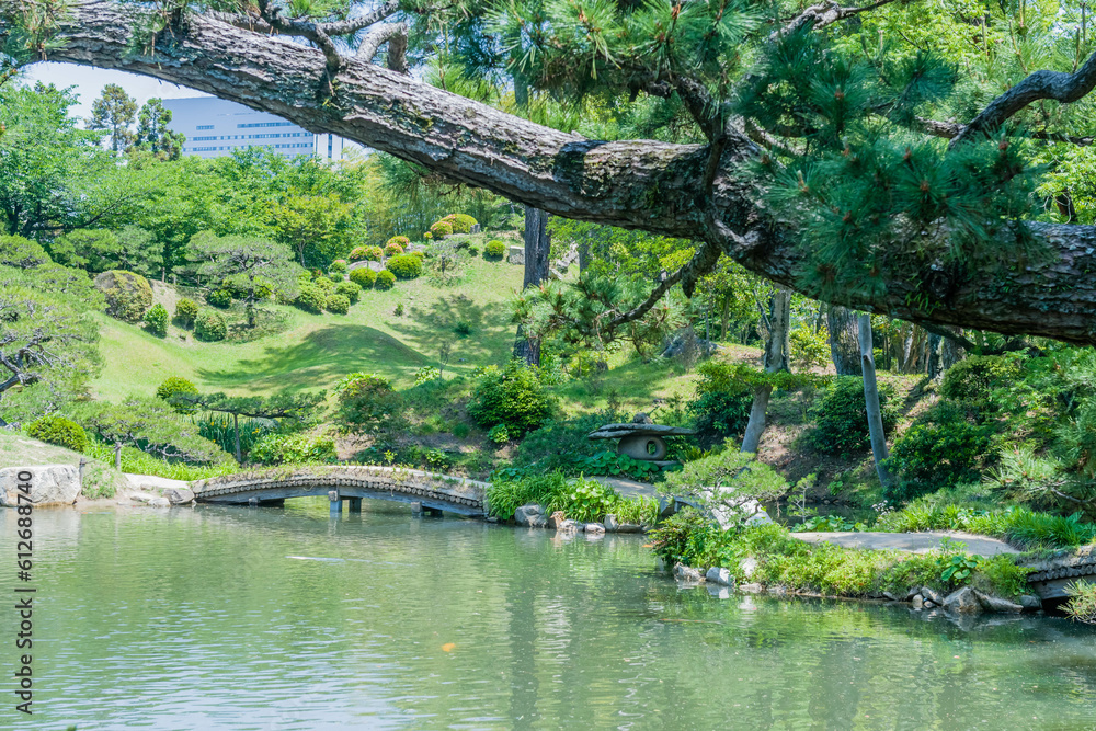 Landscape of footbridge over lake at Shukkeien Gardens in Hiroshima.