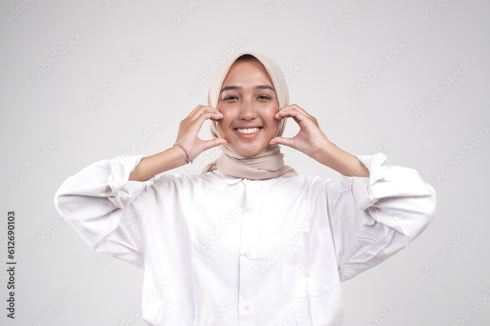Happy smiling asian muslimah make love sign on her cheek Happy smiling asian muslimah make love sign on her cheek