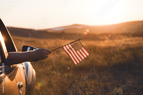 Man`s hand holding a waving american USA flag.