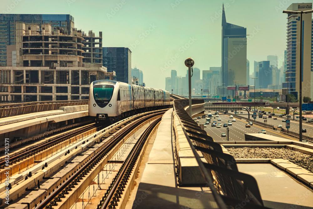 Dubai modern city with subway at urban landscape skyscrapers background. View of Metropolitan metro in downtown desert arabic emirate, train on railroad. Public transport concept. Copy ad text space