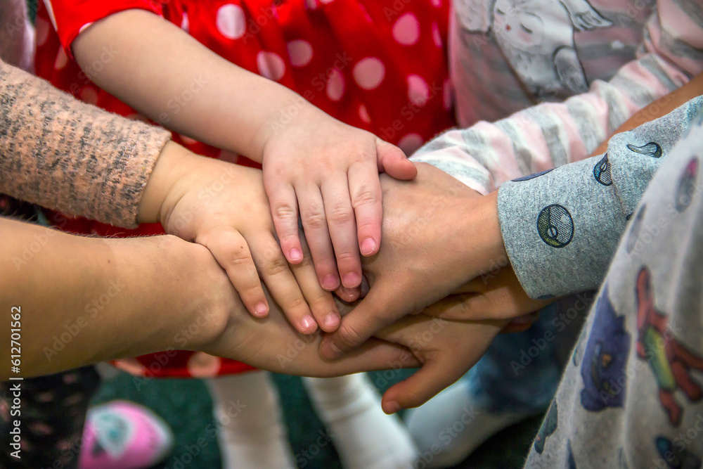 Children's hands are stacked together one on top of the other
Children's hands are stacked together one on top of the other