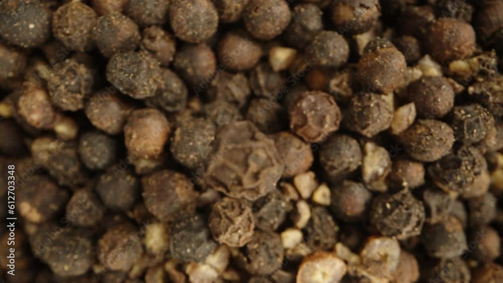 The concept of focusing on the foreground and background, a black peppercorn against a pile of other peppercorns, macro shot. The concept of focusing on the foreground and background, a black peppercorn against a pile of other peppercorns, macro shot.
