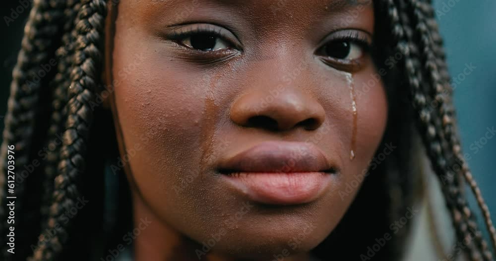 Close-up of a melle young African woman feeling upset and crying desperately. Close-up of a melle young African woman feeling upset and crying desperately.