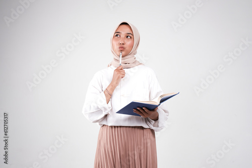 Muslimah college carrying book and pen for studying isolated white background