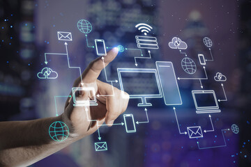 Cloud service technology concept with man finger on virtual touch screen with digital computer and electronic devices connected between each other on blurred night city background
