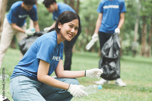 Young Asian Volunteers with garbage bags cleaning park area. Ecology, Charitable organization concept