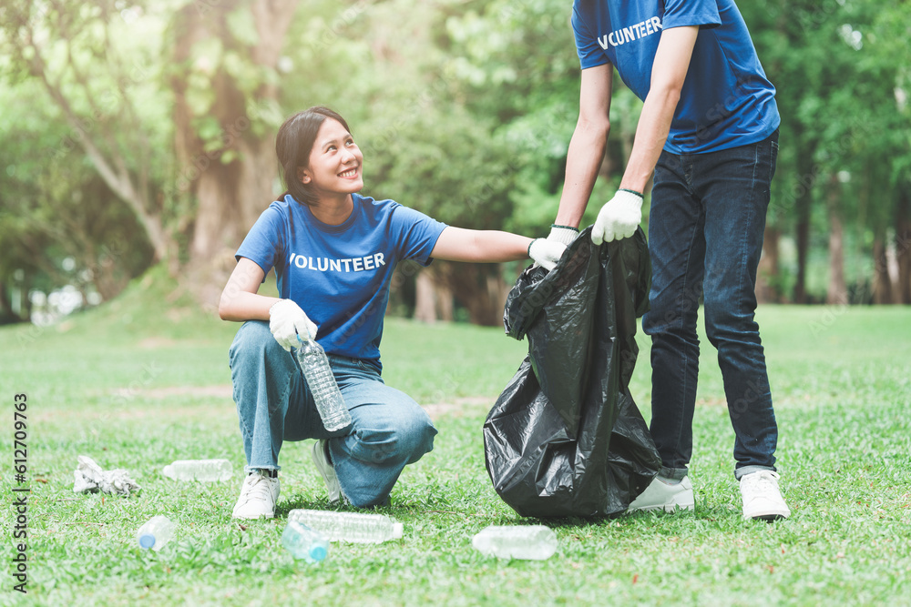 Young Asian Volunteers with garbage bags cleaning park area. Ecology, Charitable organization concept Young Asian Volunteers with garbage bags cleaning park area. Ecology, Charitable organization concept